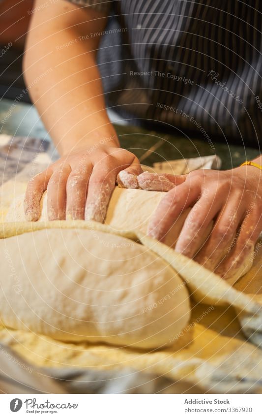 Erntemann, der auf bemehltem Tisch Teig knetet Frau kneten Teigwaren Mehl Brot Bäcker Lebensmittel Brötchen Schürze Küche Mahlzeit Müsli handgefertigt Rezept