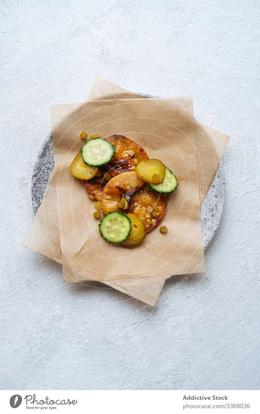 Gericht der hohen Küche mit Gurken Hohe Küche Speise Delikatesse Haute Cuisine Salatgurke eingelegt Saucen Backpapier Teller Tisch frisch Gemüse Lebensmittel