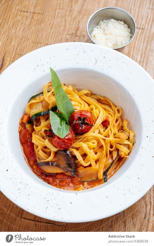 Stilvoll dekorierte Nudeln mit Zucchini Spätzle Spaghetti Italienische Küche Restaurant Tomaten Basilikum Speise Hohe Küche lecker Teller Saucen Feinschmecker