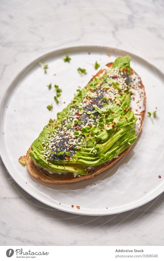 Perfektes offenes Sandwich mit Avocado Belegtes Brot Gewürz Teller Speise Gabel Stil Restaurant Gesundheit organisch natürlich Geschirr Scheibe Kraut Sahne