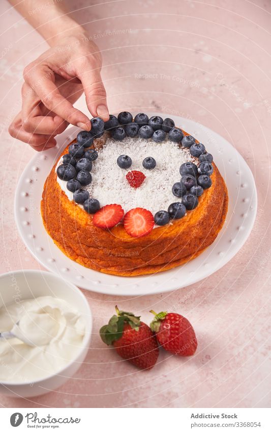 Gesichtslose Dame serviert Kuchen mit Beeren gebacken Dessert Essen zubereiten Frau Servieren dekorierend Blaubeeren Erdbeeren Sauerrahm Küchenchef