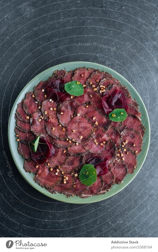 Teller mit leckerem Carpaccio im Cafe Fleisch roh Scheibe Restaurant Rote Beete Exquisit kalt Feinschmecker Amuse-Gueule Speise Lebensmittel geschmackvoll