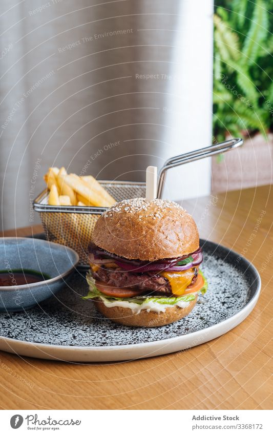 Köstlicher Burger mit gebratener Frikadelle und frischem Gemüse Fastfood Straßenessen Speise Restaurant Pastetchen Saucen Zwiebel Salat Hirschfleisch Käse