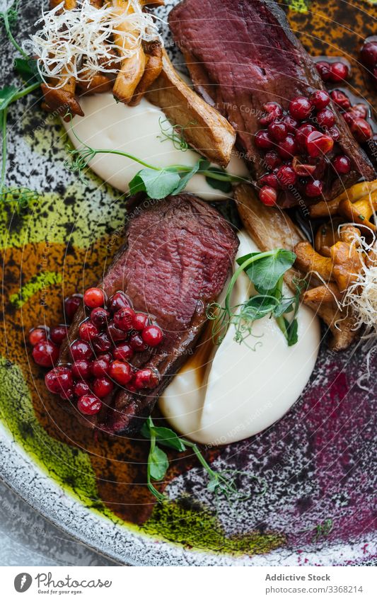 Seltenes Steak mit Preiselbeersauce selten Saucen Preiselbeere süß Käse Pilz Kraut Fleisch Teller Rindfleisch Lebensmittel Mahlzeit aufgeschnitten Spielfigur