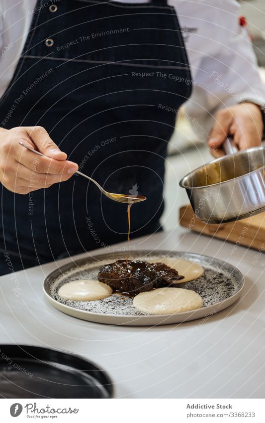 Chefkoch bereitet Delikatessen in der Restaurantküche zu Küchenchef Speise Hohe Küche haute vorbereiten Lebensmittel lecker Mahlzeit Feinschmecker Saucen Teller