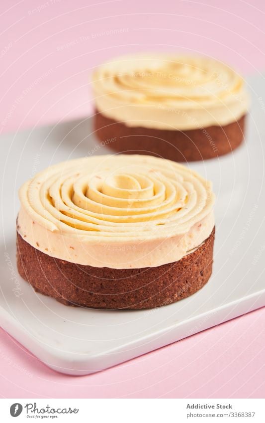 Leckere Desserts mit Sahnespirale süß Spirale Dekor Lebensmittel Gebäck Holzplatte geschmackvoll Küche Speise lecker Zucker Kalorie Portion Spielfigur gebacken