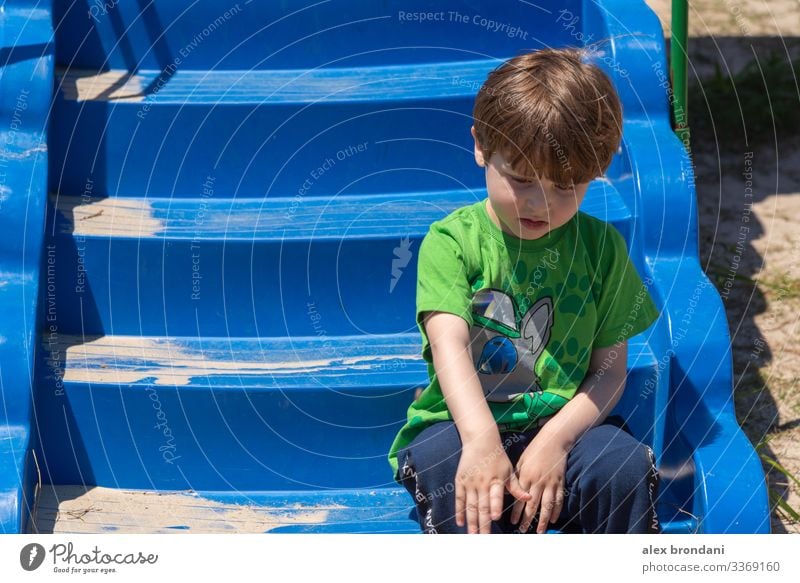 Brasilianischer Junge sitzt auf Spielzeug Treppe des Spielplatzes. Spieltag im Freien. Natur Aktivität wenig bezaubernd Person Brasilianer grün ethnisch