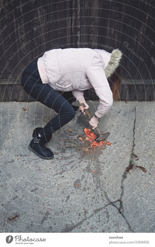 fotochallenge: jugendliche zermatscht eine überreife tomate, die geschmacklich nicht ihren erwartungen entsprach, mit einem hammer Fotochallenge Jugendliche