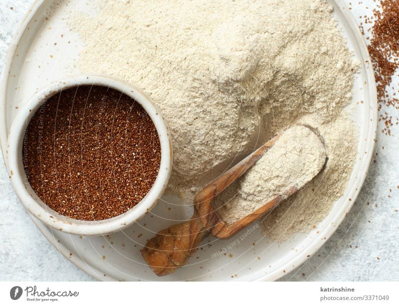 Teffmehl und Teffkorn mit einem Löffel Vegetarische Ernährung Diät Teller Holz oben Mehl Lebensmittel teff Afrikanisch glutenfrei Korn präjudjudiziell Keramik