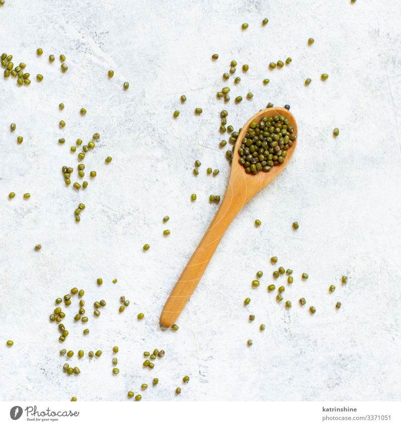 Getrocknete Mungobohnen mit einem Löffel auf weißem Hintergrund Vegetarische Ernährung Diät Tisch oben grün Mungbohnen Bohnen mung getrocknet Sehne Lebensmittel