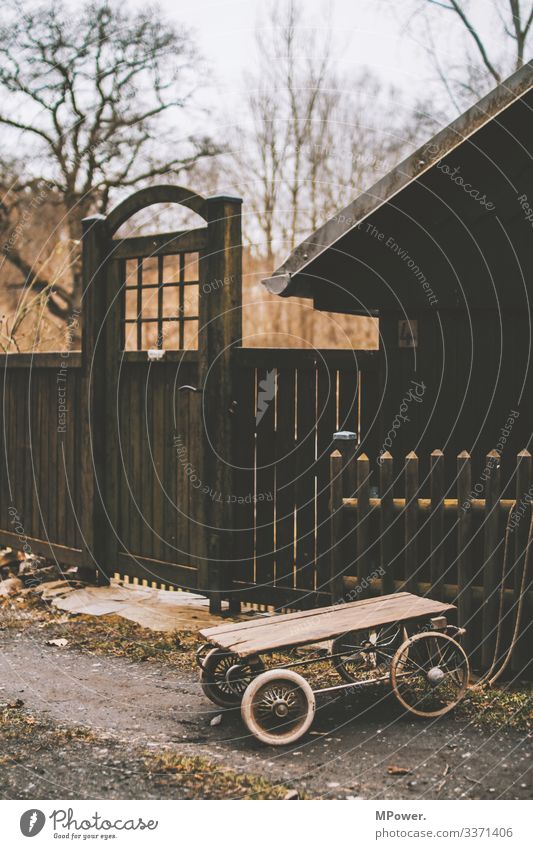 Holzwagen vor Holzhütte Tür Tor Holzhaus Dorf Dorfidylle Anhänger Aus Bretterzaun Kinderspiel Kinderspielzeug