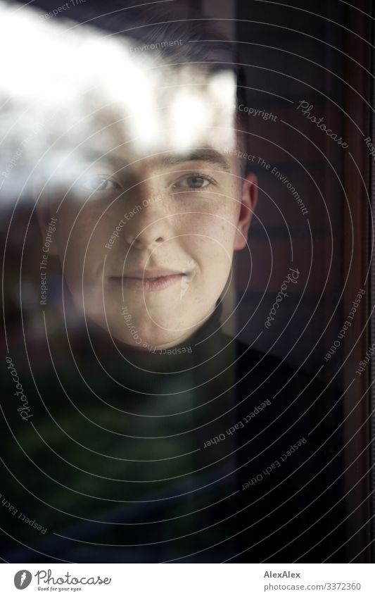 Portrait eines jungen Mannes hinter Fensterscheibe elegant Stil schön Wohlgefühl Wohnung Junger Mann Jugendliche Gesicht 18-30 Jahre Erwachsene Schönes Wetter