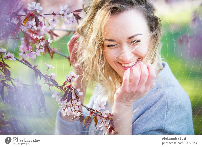 Junge Frau genießt die Natur im Frühling. Atmen frische Luft und Blumen Aroma in schönen Park mit Kirschbäumen in der Blüte. Glück Konzept Beautyfotografie