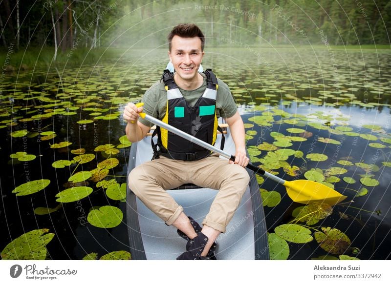 Zwei Männer in Rettungswesten beim Kanufahren auf einem Waldsee. Aktion gehen Abenteuer offen Ausflugsziel entdecken Finnland Glück See Landschaft Lifestyle