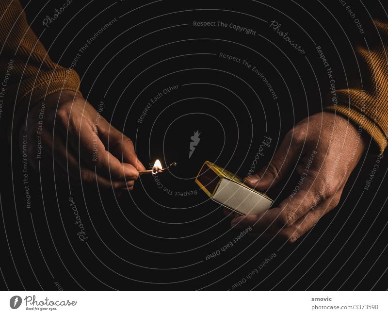 Die Hände eines erwachsenen Mannes, der ein brennendes Streichholz hält Mensch maskulin Erwachsene Leben Hand 1 30-45 Jahre Feuer Kasten Holz Rauch Armut Senior