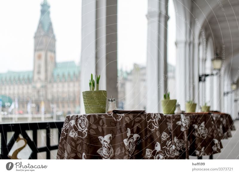 Stehtische unter Arkaden Tisch Blumentopf Frühblüher Arkadengängen Dekoration & Verzierung Architektur Symmetrie Säule Schwache Tiefenschärfe Fassade Stadtleben