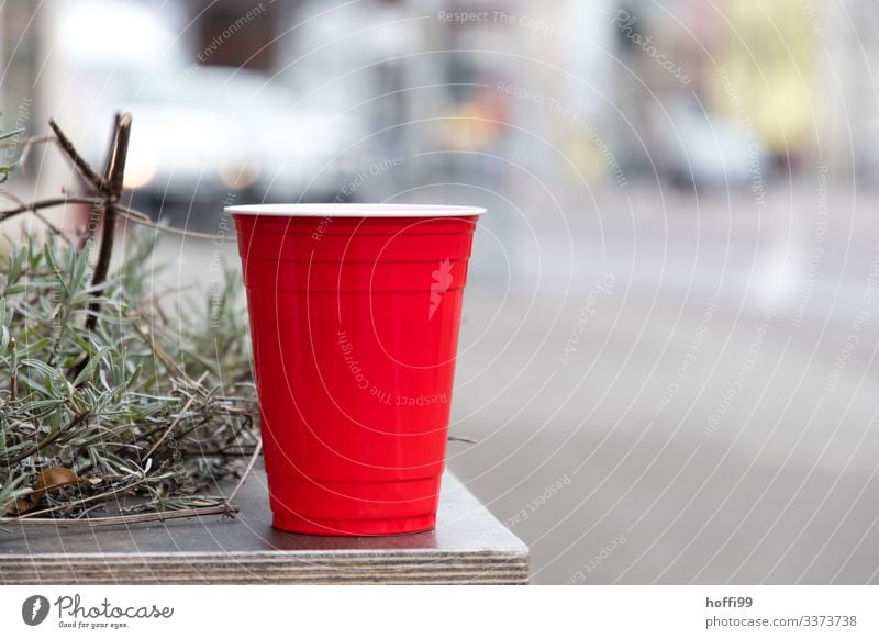 roter Plastikbecher mit Rosmarin auf einem Tisch Rot roter Becher Müll Plastikmüll Umweltbelastung Freisteller selektiver fokus