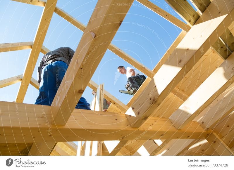 Bauarbeiter bei der Arbeit mit hölzerner Dachkonstruktion. Haus Rahmen heimwärts Bauherr Konstruktion Zimmerer Holz Dachdecker Arbeiter Gebäude Entwicklung