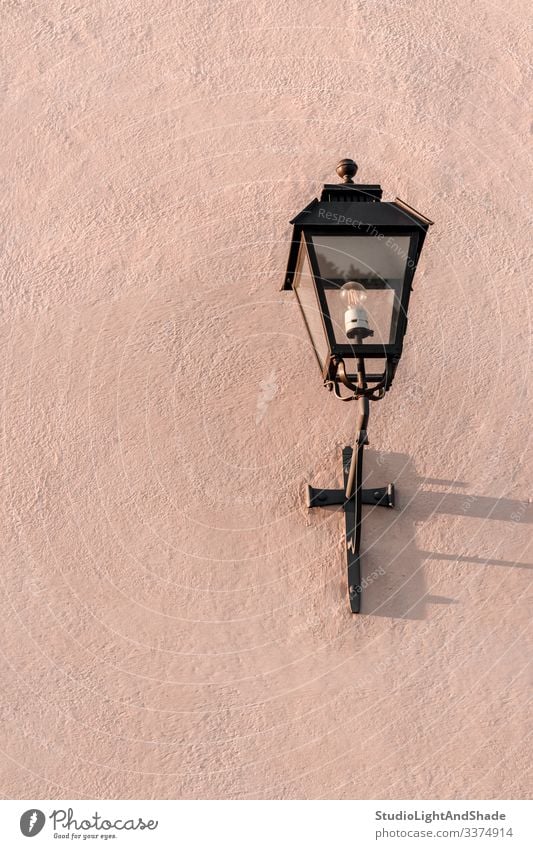 Straßenlampe auf einer strukturierten rosa Wand Straßenlaterne Licht Lampe Laterne Elektrizität gemalt Stein Hintergrund Textur Oberfläche staubig-rosa Pastell