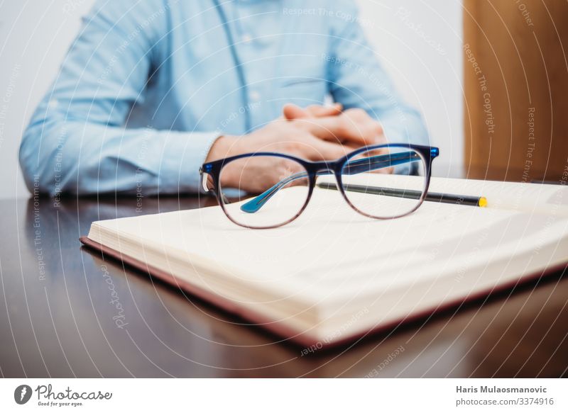 Männerhände, die am Schreibtisch sitzen, mit Buch und Brille studieren und im Büro arbeiten Tisch Bildung Schüler lernen Arbeit & Erwerbstätigkeit Beruf