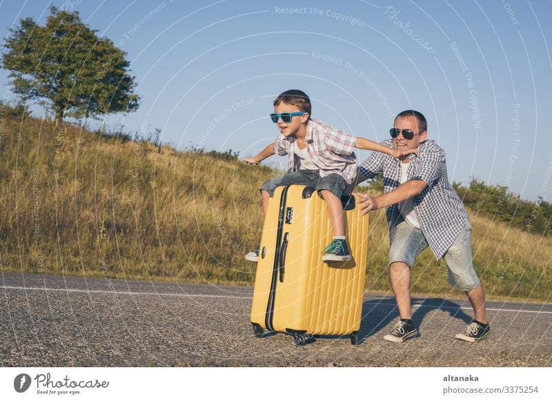 Vater und Sohn spielen zur Tageszeit auf der Straße. Die Menschen haben Spaß im Freien. Konzept eines glücklichen Urlaubs und einer freundlichen Familie.