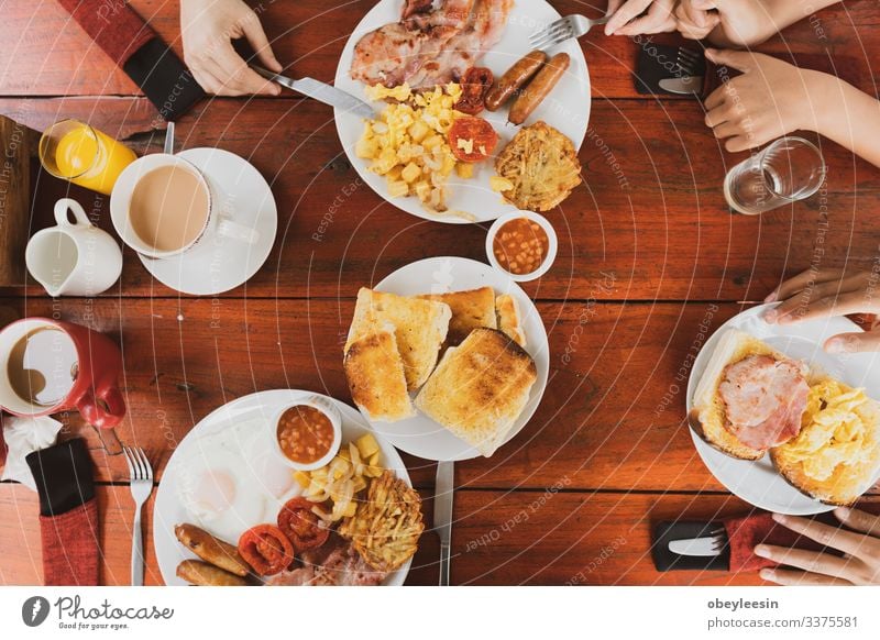 Junge glückliche Familie beim Frühstück Frucht Brot Croissant Marmelade Essen Getränk Saft Kaffee Teller Lifestyle Ferien & Urlaub & Reisen Tisch Küche Stein