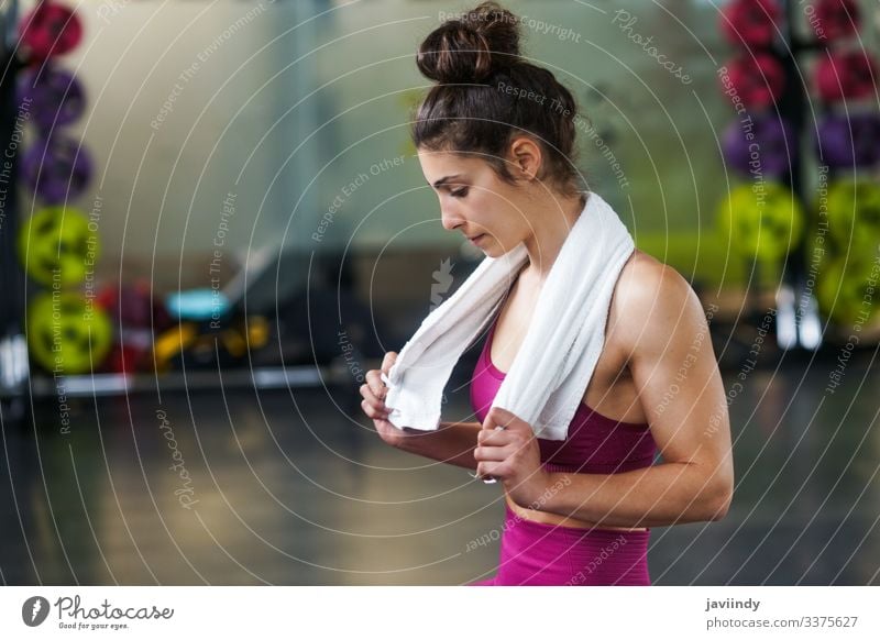 Frau ruht sich nach den Übungen in der Turnhalle aus Handtuch ruhen Pause Mädchen aussruhen jung Sitzen aktiv Fitnessstudio Sport passen Gesundheit Lifestyle