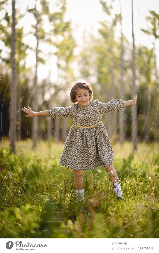 Kleines Mädchen im Naturfeld mit schönem Kleid wenig Kind Glück Kinder Frühling außerhalb Sommer Wiese Spielen Porträt im Freien Mode Fröhlichkeit Baby Blumen