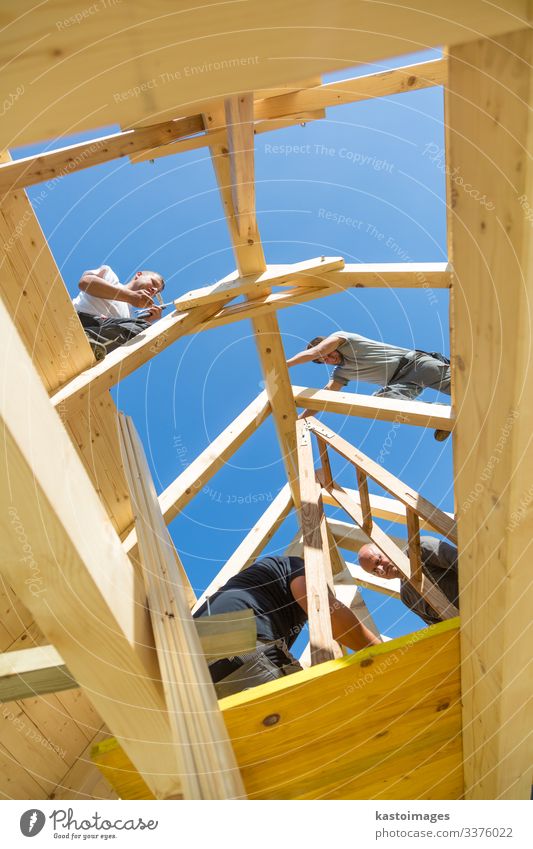 Dachdecker, die vorgefertigte Holzdachkonstruktionen montieren. Konzept der Bauindustrie. Haus Arbeit & Erwerbstätigkeit Handwerker Baustelle Industrie Werkzeug