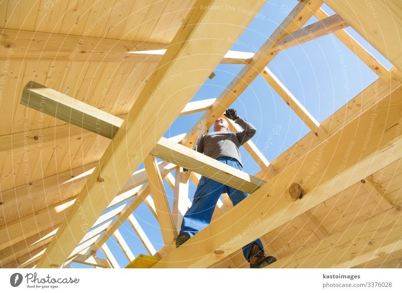 Baumeister bei der Arbeit mit hölzerner Dachkonstruktion. Haus Arbeit & Erwerbstätigkeit Handwerker Baustelle Industrie Werkzeug Hammer Mensch Mann Erwachsene