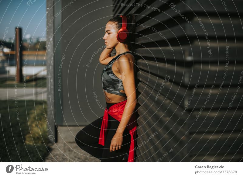 Hübsche junge Frau macht eine Pause nach einem Lauf im Stadtgebiet Lifestyle Erholung Joggen Headset Mensch Junge Frau Jugendliche Erwachsene 1 18-30 Jahre