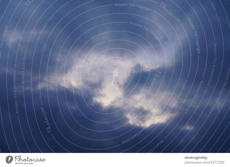 Dunkel blaue Regen Wolken mit Durchblick in die höhere Atmosphäre zur Dämmerung. Eher düstere Stimmung mit einem Lichtblick. Luftraum Meteorologie Pilot Umwelt