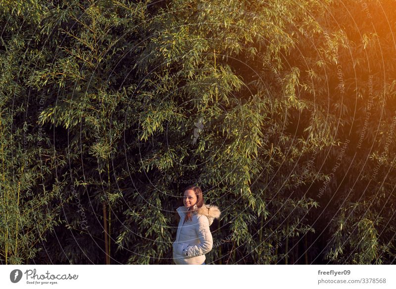 Junge Frau vor einer Bambusplantage jung Schonung Blätter grün Gras Natur Pflanzen Japanisch Blatt Kultur Garten tropisch Hintergrund Zen Frische Baum Asien