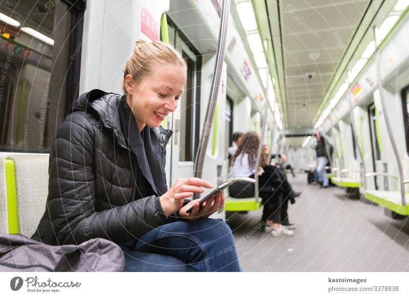 Ein junges Mädchen liest in der U-Bahn vom Bildschirm eines Mobiltelefons. Lifestyle Ferien & Urlaub & Reisen Ausflug Dekoration & Verzierung Business Telefon