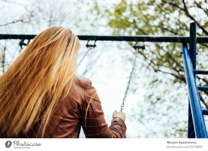 Junge Frau auf einer Schaukel auf einem Spielplatz Lifestyle Freude Freiheit Mensch feminin Jugendliche Erwachsene Leben 1 30-45 Jahre genießen schaukeln