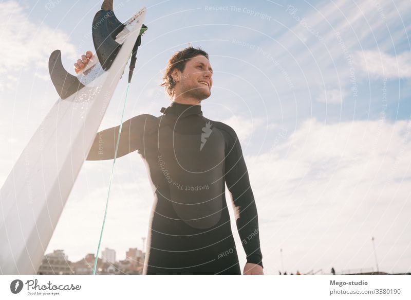 Surfer, der mit einem Surfbrett am Strand steht. Mann Brandung Wasser Sport Surfen MEER Meer im Freien sportlich Küstenlinie Wellen Hintergrund Abenteuer