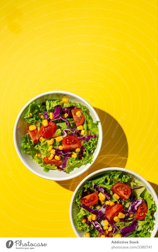 Frischer Kopfsalat mit Kirschtomaten Salatbeilage Lebensmittel Salatkopf Mais rote Zwiebel Sonnenlicht frisch Gemüse Veganer Vegane Ernährung gesunde Ernährung