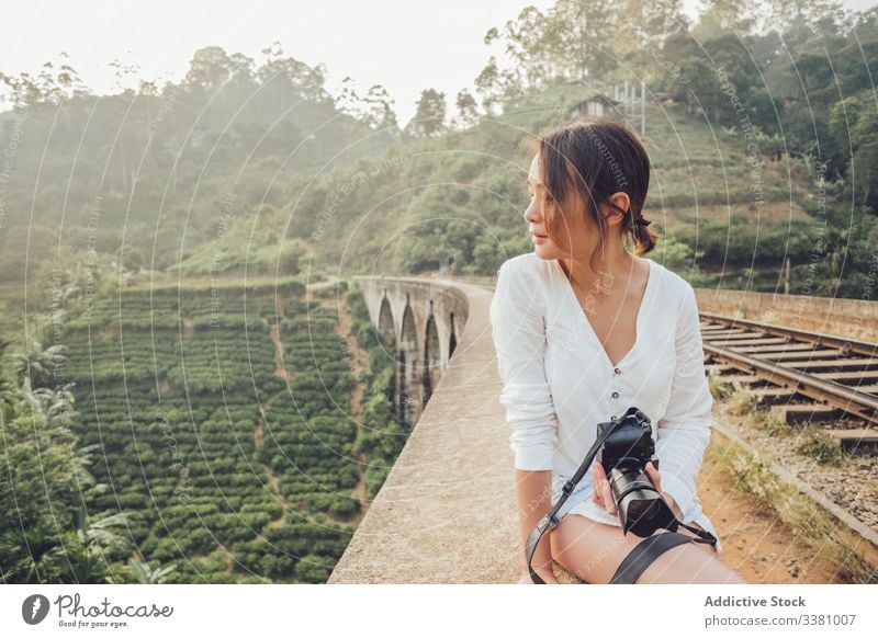 Junge Asiatin im Urlaub beim Fotografieren mit der Kamera in der Natur Frau Märchenfoto Fotokamera reisen exotisch Dschungel Eisenbahn erkunden Ansicht