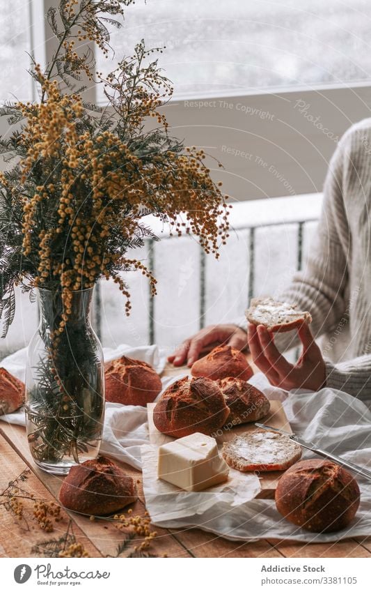 Gesichtslose Dame streicht Butter auf Brot in der Küche mimosas Frau Aufstrich Koch Morgen Frühstück vorbereiten Tisch heimwärts Blume Mittagessen kulinarisch