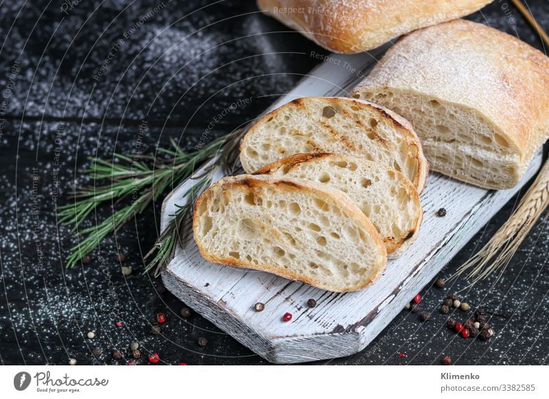 Ciabatta mit Rosmarin, Olivenöl und Kirschtomaten auf einem Holzbrett. Auf einem dunklen Hintergrund. Salatbeilage Spinat Speck Belegtes Brot Erdöl Italien