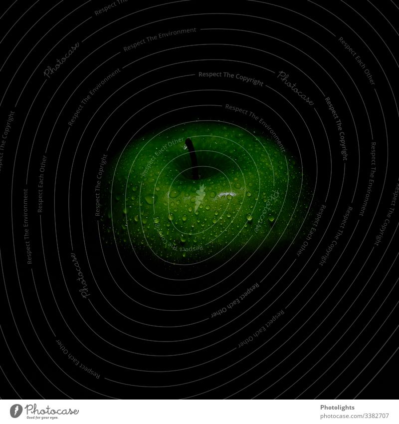 Grüner Apfel mit Wassertropfen und schwarzem Hintergrund Ernte grüner apfel Ernährung knackig apfelbaumdetail Stengel Frucht dunkel lecker frisch Vitamin