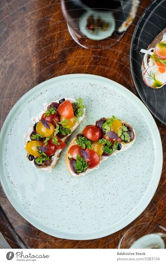 Sandwiches mit Kirschtomaten auf Brot auf Tisch mit Wein Tomaten Kirsche Belegtes Brot Zuprosten Glas lecker Lebensmittel geschmackvoll Feinschmecker Getränk