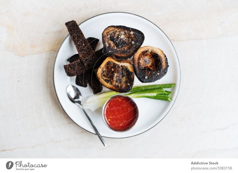 Aperitif der hohen Küche im Restaurant Amuse-Gueule Snack Croutons rustikal Saucen Teller Tisch Frühlingszwiebel Löffel Knusprig gebraten geräuchert Spielfigur