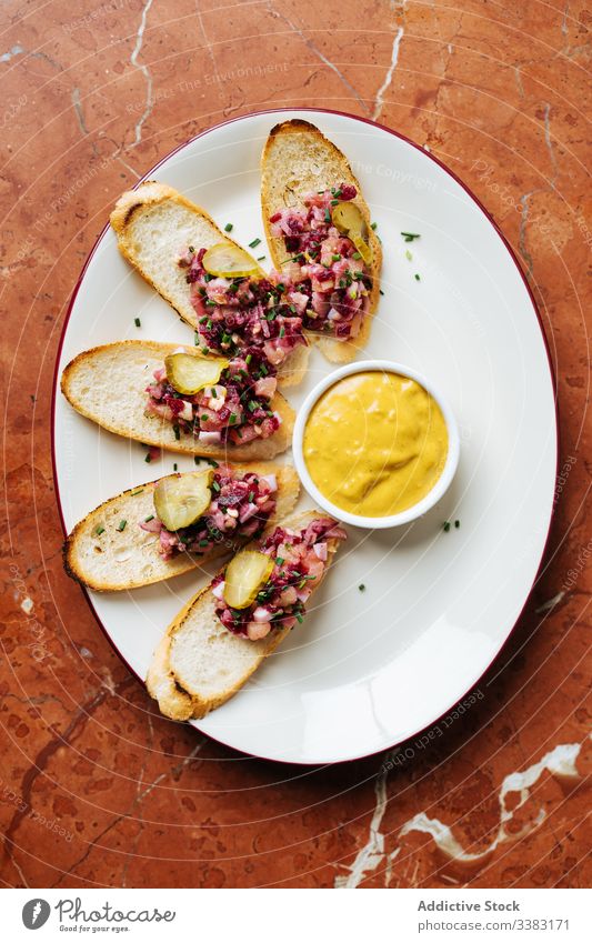 Schmackhafte Bruschetta mit Salat und Sauce im Restaurant Salatbeilage Speise Brot Hohe Küche Zuprosten Salatgurke Saucen farbenfroh Vinaigrette gebacken lecker