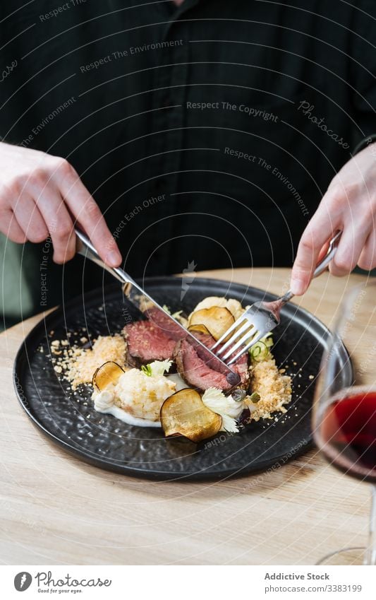 Person, die zum Essen Roastbeef mit Gemüse isst Vanillerostbraten Chip Abendessen Rindfleisch Scheibe Gastronomie Blumenkohl Besteck Restaurant Sahne Saucen