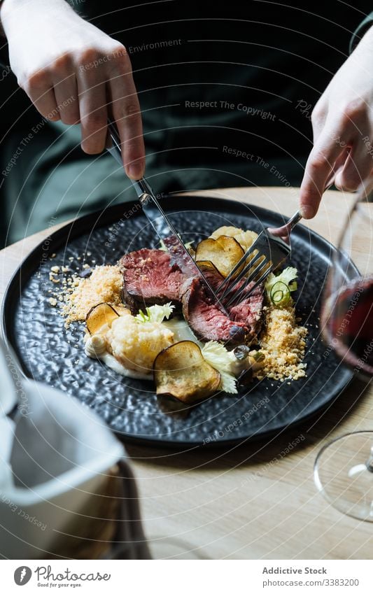 Person, die zum Essen Roastbeef mit Gemüse isst Vanillerostbraten Chip Abendessen Rindfleisch Scheibe Gastronomie Blumenkohl Besteck Restaurant Sahne Saucen