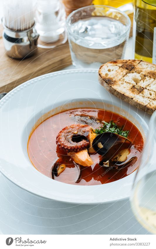 Köstliches Tom Yum mit Tintenfisch im Restaurant Suppe Meeresfrüchte Octopus Muscheln Asiatische Küche Haute Cuisine Kraut Grün lecker Mahlzeit geschmackvoll