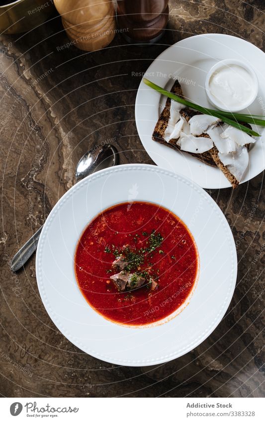 Borschtsch mit Brot und Speck auf dem Tisch im Restaurant serviert Suppe Speise lecker Mahlzeit Lebensmittel Küche geschmackvoll Feinschmecker Zwiebel frisch