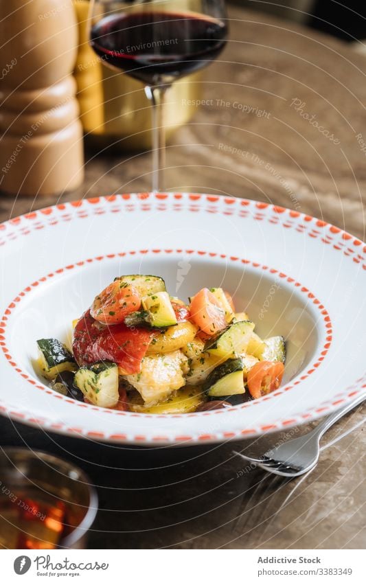 Gemüsesalat in weißer Platte auf Marmortisch im Restaurant Salatbeilage Tomate Blumenkohl grün Veganer kulinarisch Kraut Lebensmittel geschmackvoll lecker