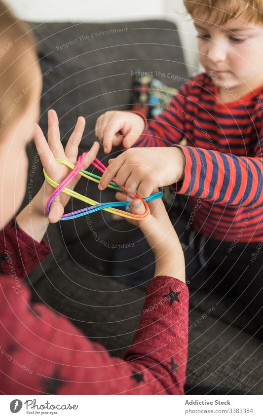 Kluge Kinder benutzen Gummibänder beim Spiel Band kreativ farbenfroh lernen Erziehung spielen elastisch Zusammensein wenig Handfläche verdrehen lässig heimwärts